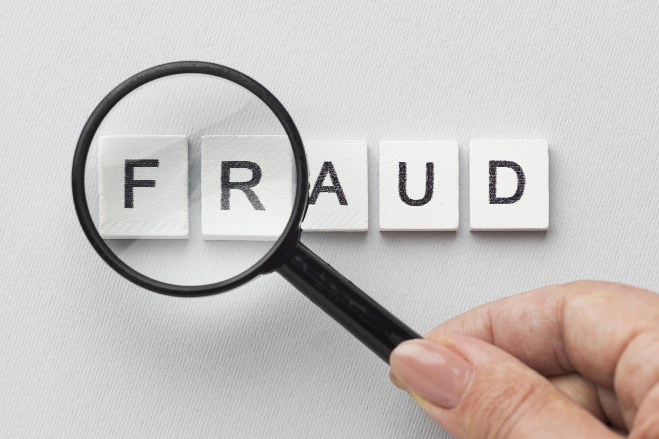 Fraud word magnifying glass scaled