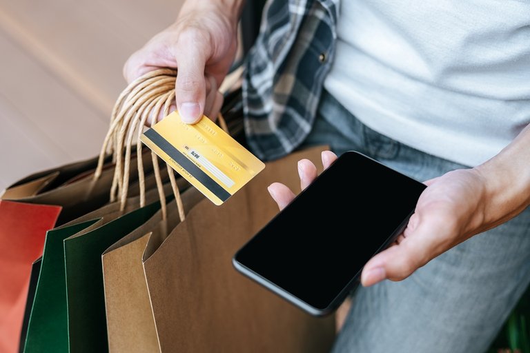 Hand Of Man Holding Shopping Bags With Credit Card And Smartphon
